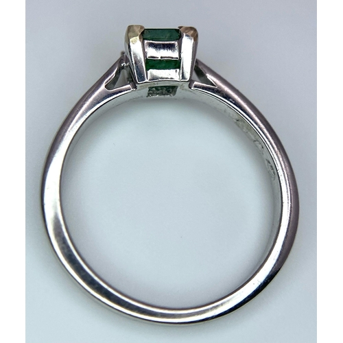 1186 - AN 18K WHITE GOLD RING WITH SQUARE EMERALD CENTRE STONE .   3.3gms   size N