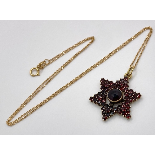 661 - A 14K Gold and Garnet Star Pendant on an 18K Yellow Gold Disappearing Necklace. 3cm and 44cm.4.5g to... 