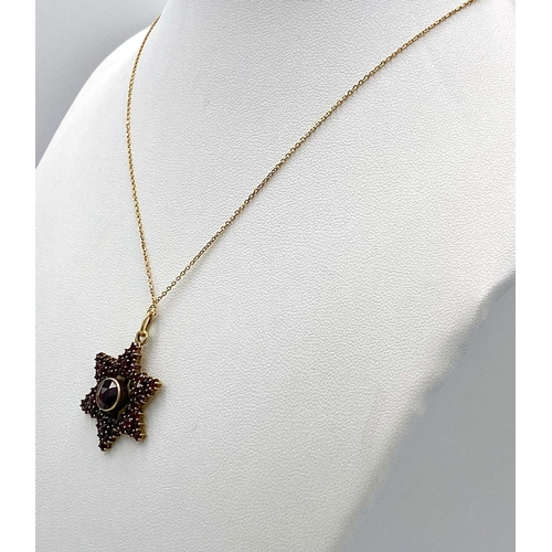 661 - A 14K Gold and Garnet Star Pendant on an 18K Yellow Gold Disappearing Necklace. 3cm and 44cm.4.5g to... 