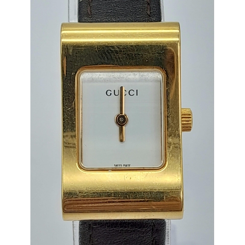 1411 - A Gucci 2300L Quartz Ladies Watch. Brown leather strap. Gilded case - 17mm. White dial. In need of a... 