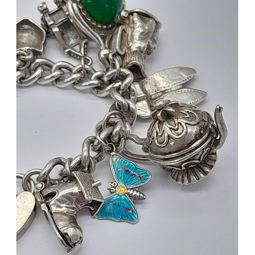 1450 - A SILVER CHARM BRACELET WITH 17 VERY COLLECTABLE CHARMS TO INCLUDE HEDGEHOG , BUTTERFLY , TEA POT , ... 