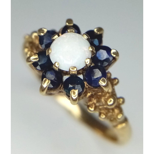 1657 - A Vintage 9K Yellow Gold Opal and Sapphire Ring. Central opal with a sapphire cluster. Size P. 3.08g... 