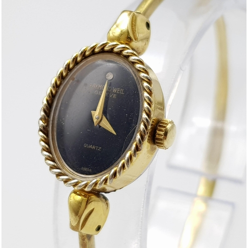 1215 - A Gilded Raymond Weil Ladies Quartz Watch. Gilded clip open bangle bracelet. Oval case - 16mm. Black... 