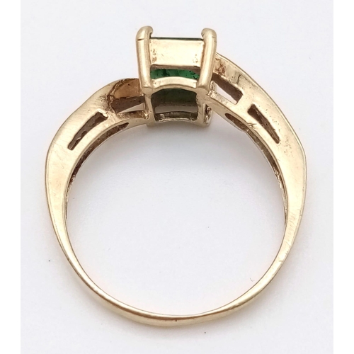 1246 - A 1ct EMERALD IN A 9K GOLD RING WITH WHITE SAPPHIRE SHOULDERS .  2.6gms   size O