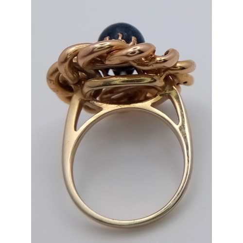 1343 - AN 18K GOLD SWIRL RING WITH DIAMONDS AND LARGE CIRCULAR SAPPHIRE .   10.3gms   size N/O