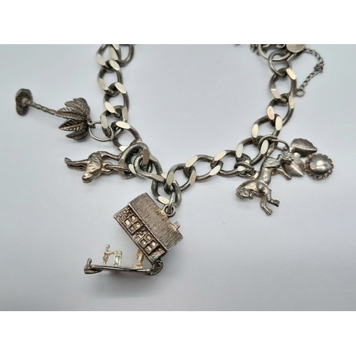 1516 - A SILVER CHARM BRACELET WITH 8 CHARMS .  30gms