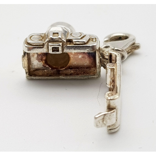 1265 - A STERLING SILVER CAMERA CHARM WHICH OPENS TO REVEAL A COUPLE HOLDING HANDS 5.1G

ref: SC 3127