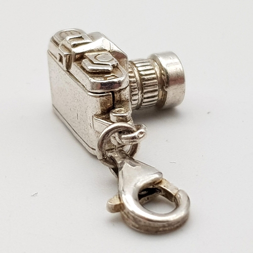 1265 - A STERLING SILVER CAMERA CHARM WHICH OPENS TO REVEAL A COUPLE HOLDING HANDS 5.1G

ref: SC 3127