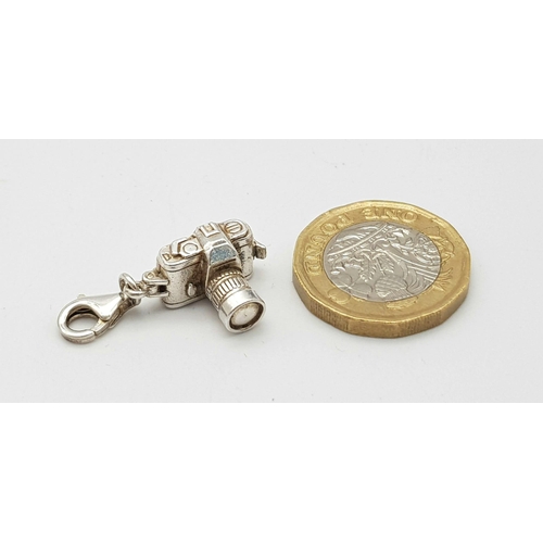 1265 - A STERLING SILVER CAMERA CHARM WHICH OPENS TO REVEAL A COUPLE HOLDING HANDS 5.1G

ref: SC 3127