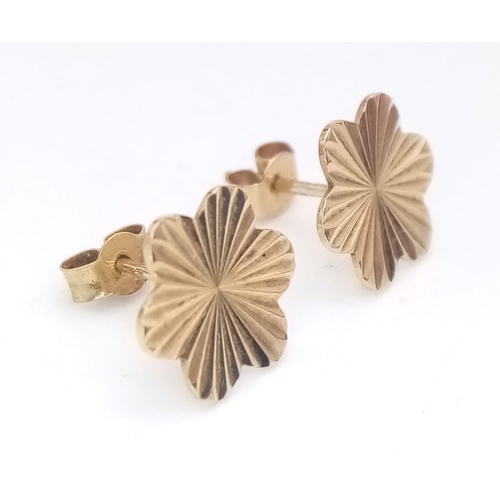 1264 - A 9k yellow gold floral shaped studs with linear detailing, 0.7g

ref: SH1395I-5