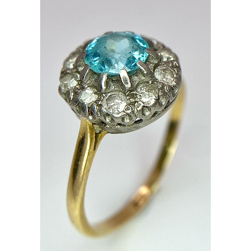 18 - An 18K Yellow Gold Aquamarine and Diamond Ring. Sky blue aquamarine with a diamond halo. Size K. 2.7... 