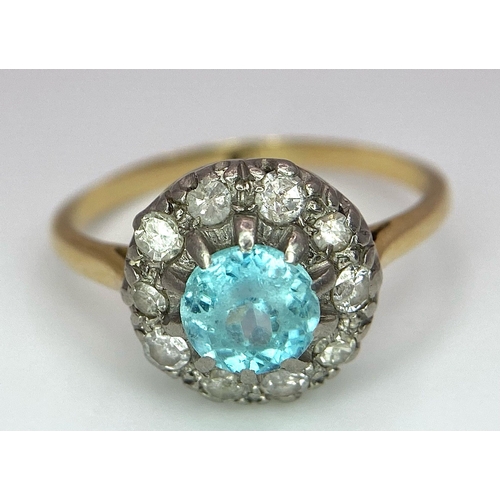 18 - An 18K Yellow Gold Aquamarine and Diamond Ring. Sky blue aquamarine with a diamond halo. Size K. 2.7... 