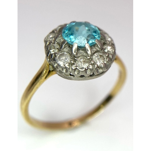 18 - An 18K Yellow Gold Aquamarine and Diamond Ring. Sky blue aquamarine with a diamond halo. Size K. 2.7... 