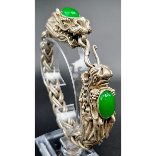 238 - A Vintage, Chinese silver, double headed dragon bracelet with two green jade cabochons. In a present... 