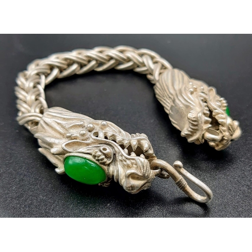 238 - A Vintage, Chinese silver, double headed dragon bracelet with two green jade cabochons. In a present... 