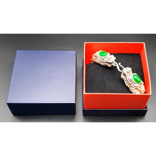 238 - A Vintage, Chinese silver, double headed dragon bracelet with two green jade cabochons. In a present... 