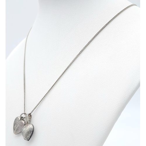 1012 - A vintage sterling silver necklace with 2 silver heart locket pendants. Total weight 5.6G. Total len... 