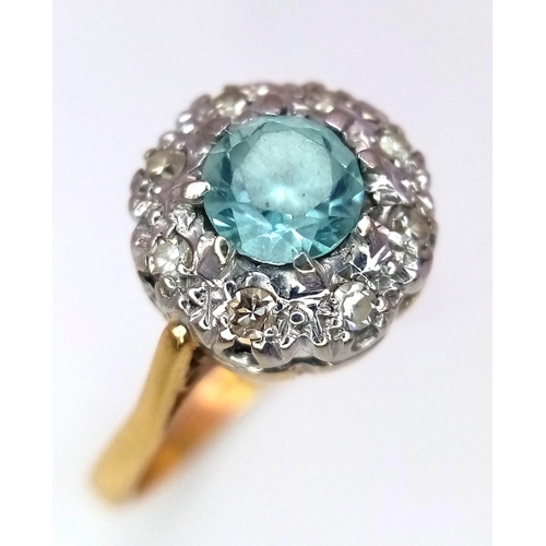 312 - A Vintage 18K Yellow Gold Aquamarine and Diamond Ring. Central aquamarine with a diamond halo. Size ... 