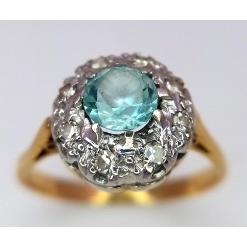 312 - A Vintage 18K Yellow Gold Aquamarine and Diamond Ring. Central aquamarine with a diamond halo. Size ... 