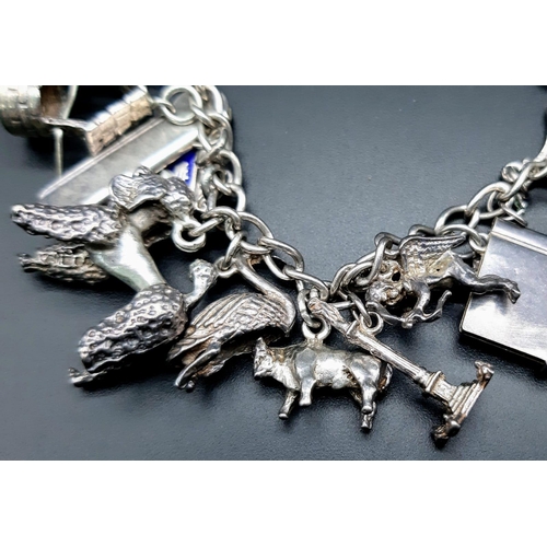 1300 - A vintage sterling silver bracelet with multiple charms such as Eiffel Tower, old motives, animals, ... 