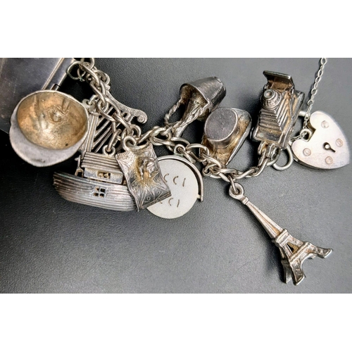 1300 - A vintage sterling silver bracelet with multiple charms such as Eiffel Tower, old motives, animals, ... 