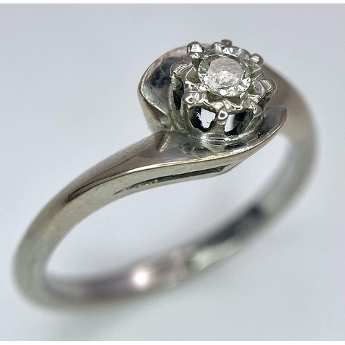 351 - An 18K White Gold Diamond Crossover Ring. 0.10ct brilliant round cut diamond. Size N. 4g total weigh... 