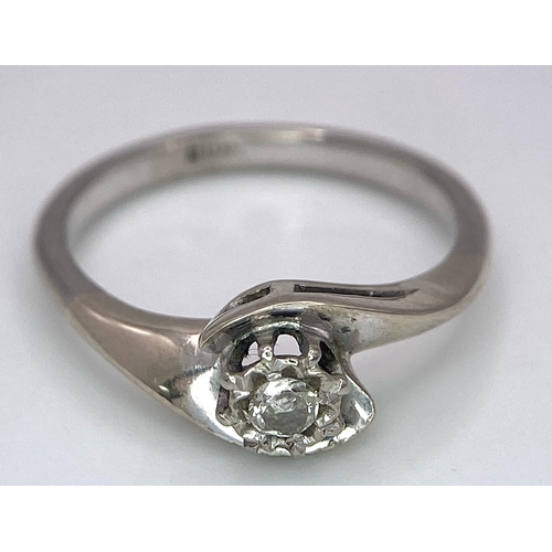 351 - An 18K White Gold Diamond Crossover Ring. 0.10ct brilliant round cut diamond. Size N. 4g total weigh... 