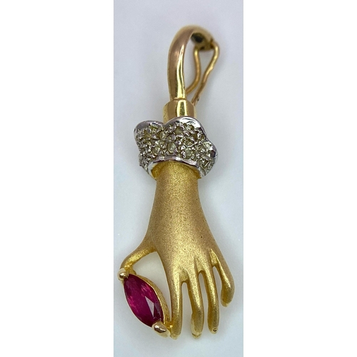 430 - A 14K Yellow Gold, Diamond and Ruby Hand Pendant. A diamond wristed feminine hand gently caresses a ... 