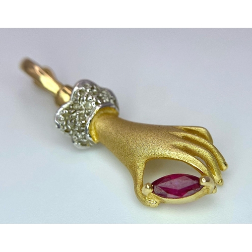 430 - A 14K Yellow Gold, Diamond and Ruby Hand Pendant. A diamond wristed feminine hand gently caresses a ... 