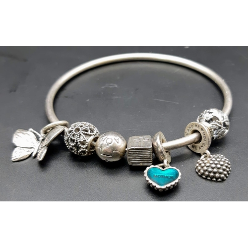 935 - A vintage 925 silver Pandora charm bangle. Total weight 26.3G.  Diameter 7.5cm. Please see photos fo... 