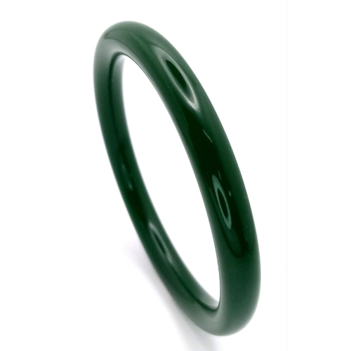 465 - A Thin Chinese Dark Green Jade Bangle. 7mm width. 6cm inner diameter.