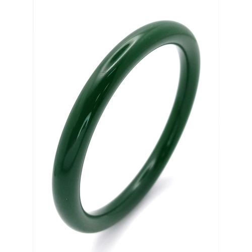 465 - A Thin Chinese Dark Green Jade Bangle. 7mm width. 6cm inner diameter.