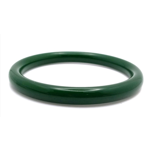 465 - A Thin Chinese Dark Green Jade Bangle. 7mm width. 6cm inner diameter.