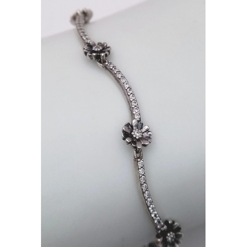 851 - A sparkling Pandora 925 silver stone set daisy flower link bracelet. Total weight 4.4G. Total length... 