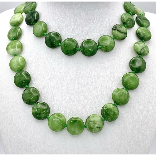 247 - A Green and White Jade Coin Bead Necklace. 14mm beads. 68cm length.