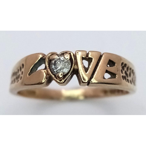 596 - A 9K Yellow Gold 'Love' Ring with White Stone Decoration. 
Size O/P. 2.52g weight.