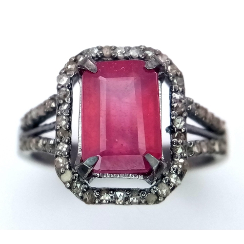 920 - A Rectangular Shaped Ruby and Diamond Ring set in 925 gun-metal silver. Central ruby with diamond su... 