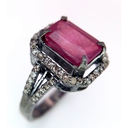 920 - A Rectangular Shaped Ruby and Diamond Ring set in 925 gun-metal silver. Central ruby with diamond su... 