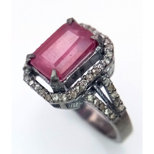 920 - A Rectangular Shaped Ruby and Diamond Ring set in 925 gun-metal silver. Central ruby with diamond su... 