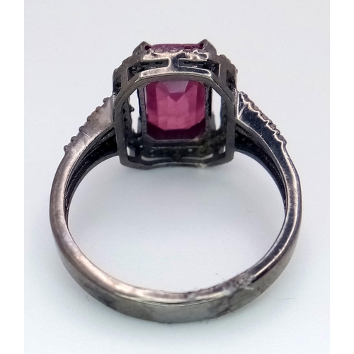 920 - A Rectangular Shaped Ruby and Diamond Ring set in 925 gun-metal silver. Central ruby with diamond su... 