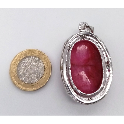 787 - An Oval Shape Ruby Gemstone Pendant set in 925 Silver with Ruby Accents. 24.20g total weight. 95ctw ... 