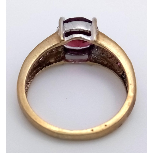 624 - A 9K Yellow Gold Garnet and Ruby Ring. Central garnet with ruby accents. Size K. 3.05g total weight.