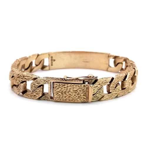 471 - A CHUNKY 9K GOLD I.D. BRACELET WITH BARK EFFECT LINKS AND SAFETY CHAIN .   59.2gms