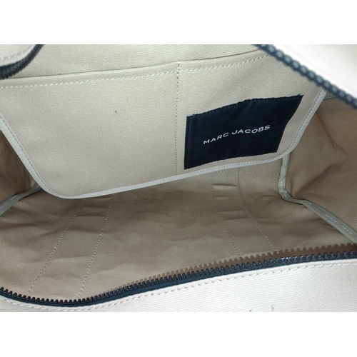 220 - A Marc Jacobs Beige 'The Tote Bag'. Canvas exterior with two handles, and top zip closure. Canvas in... 