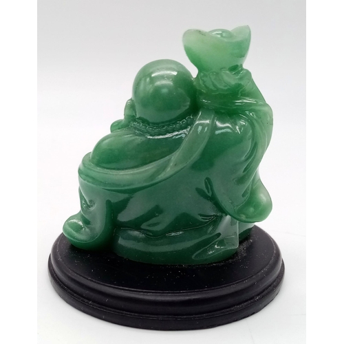 262 - A GREEN JADE AMITABHA BUDDHA , SMILING AND BRINGING JOY AND HAPPINESS SEATED ON A BLACK HARDWOOD PLI... 