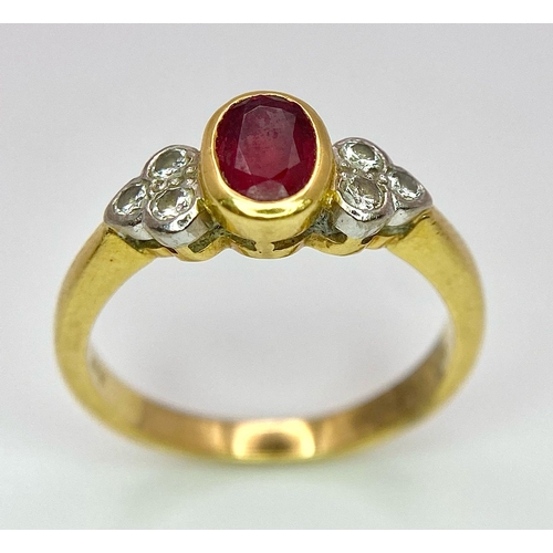 32 - An 18K Yellow Gold Ruby and Diamond Ring. Central oval ruby with six round cut diamond accents. Size... 