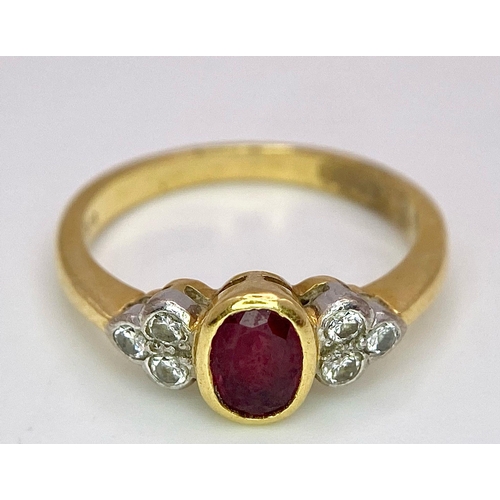 32 - An 18K Yellow Gold Ruby and Diamond Ring. Central oval ruby with six round cut diamond accents. Size... 