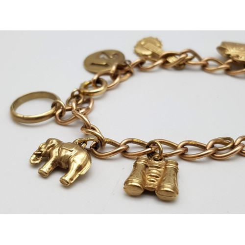 380 - A 9K Gold Charm Bracelet. 10 charms including: 10 shilling note, handbag and binoculars! 18cm length... 