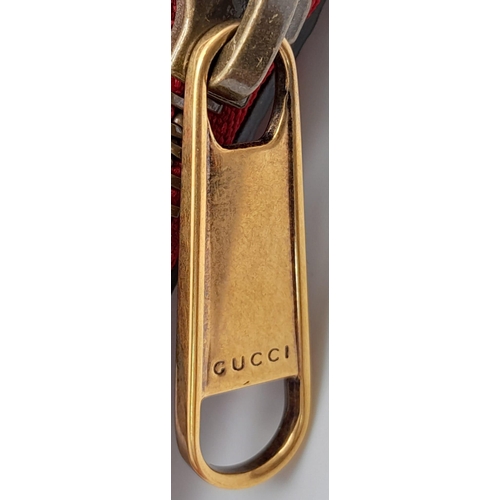 74 - A Gucci Red Logo Shoulder Bag. Leather exterior with gold-toned hardware, adjustable strap and zippe... 