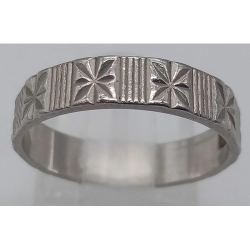 223 - A PATTERNED PLATINUM BAND RING .  4.6gms   size N